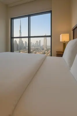 a hotel room with a large bed and a large window at The Greendoor Downtown - Burj view in Dubai