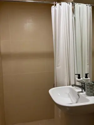 a bathroom with a sink and a white shower curtain at The Greendoor Downtown - Burj view in Dubai