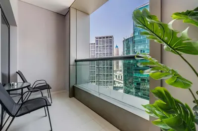 a balcony with a table and chairs and a large window at Knokey Cozy Studio Apartments in Business Bay in Dubai