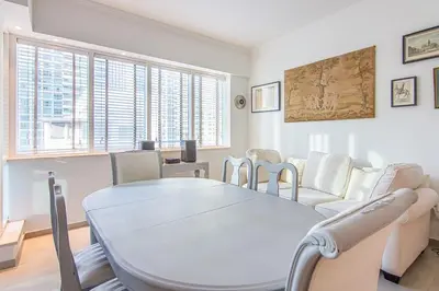 a white living room with a table and chairs at Modern 1BR with Balcony and Marina Views in Al Majara 2 in Dubai