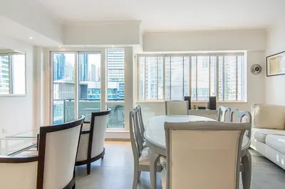 a dining room with a table and chairs and a couch at Modern 1BR with Balcony and Marina Views in Al Majara 2 in Dubai