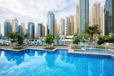 a large swimming pool in a city with tall buildings at Modern 1BR with Balcony and Marina Views in Al Majara 2 in Dubai
