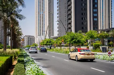 a city street with cars driving down a road with tall buildings at Creek Harbour Skyline Burj Khalifa & Sea View in Dubai