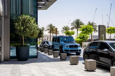a blue truck parked on a street next to cars at Creek Harbour Skyline Burj Khalifa & Sea View in Dubai
