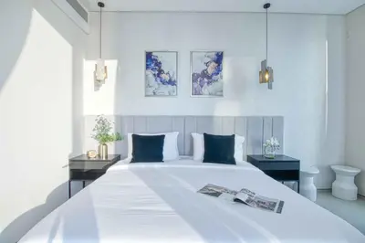 a bedroom with a large white bed with blue pillows at Address Beach Resort - 1BDR With Private Beach in Dubai