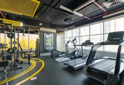 a gym with treadmills and ellipticals in a room at Apartment in Downtown As Dormitory Room for male in Dubai