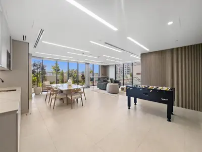 a living room with a ping pong table and a dining room at Modern Studio close to Marina with Balcony - 5 min walk from Metro in Dubai