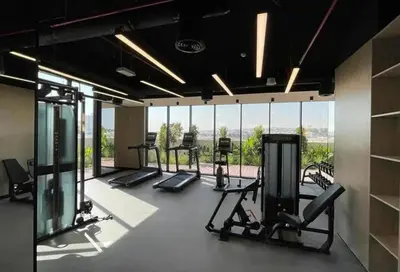 a gym with cardio equipment and a large window at Modern Studio close to Marina with Balcony - 5 min walk from Metro in Dubai