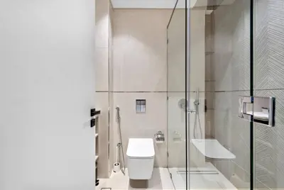 a bathroom with a shower and a toilet and a sink at Modern Studio close to Marina with Balcony - 5 min walk from Metro in Dubai