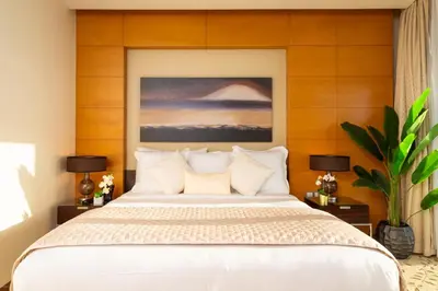 a bedroom with a large white bed with wooden walls at Emmar fashion avenue Dubai mall in Dubai