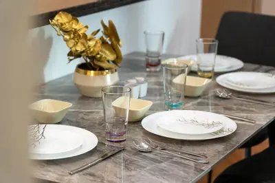a table with white plates and silverware on it at Luxury 1BR Suite I Boulevard View I Downtown Dubai in Dubai