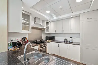 a kitchen with white cabinets and a sink at Luxury 1BR Suite I Boulevard View I Downtown Dubai in Dubai