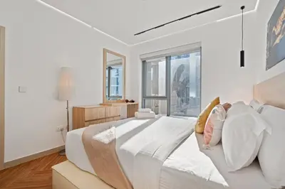 a white bedroom with a large bed and windows at Luxury 1BR Suite I Boulevard View I Downtown Dubai in Dubai