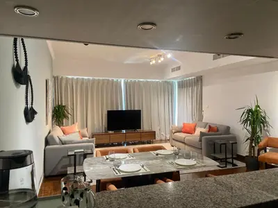 a living room with a couch and a table at Sky High luxury Stay in Dubai Marina ,with Marina View, High Floor, Modern Design, Pool Access by Stay Vista! Up to 6 Guests in Dubai