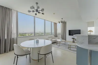 a living room with a table and chairs and a television at Luxury 2BR Sky Gardens Appartment Downtown DIFC in Dubai