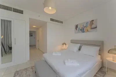 a white bedroom with a white bed and a mirror at Luxury 2BR Sky Gardens Appartment Downtown DIFC in Dubai