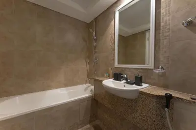 a bathroom with a sink and a tub and a mirror at Luxury 2BR Sky Gardens Appartment Downtown DIFC in Dubai