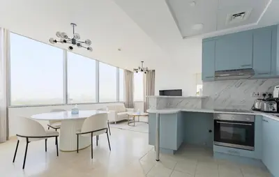 a kitchen and dining room with blue cabinets and a table at Luxury 2BR Sky Gardens Appartment Downtown DIFC in Dubai