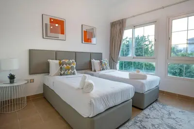 two beds in a room with two windows at Dubai Villa - Beautifully Appointed in Dubai