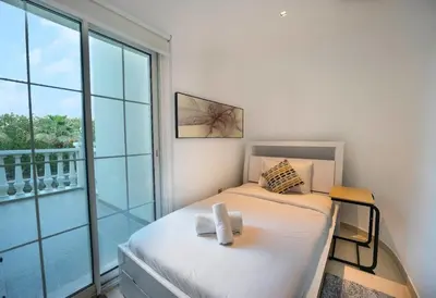 a bedroom with a bed and a large window at Dubai Villa - Beautifully Appointed in Dubai