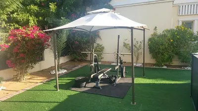 a garden with an umbrella and a chair under it at Dubai Villa - Beautifully Appointed in Dubai