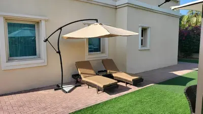a couple of chairs and an umbrella on a patio at Dubai Villa - Beautifully Appointed in Dubai