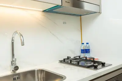 a kitchen counter with a sink and a stove at PVH - Cozy Studio in Azizi Riviera 43 in Dubai