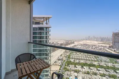 a bench on a balcony with a view of a city at PVH - Sobha Waves - Serene 1BR minutes to Downtown in Dubai
