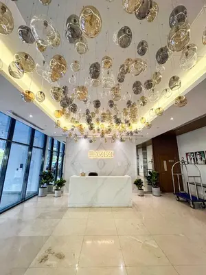 a large lobby with a table and a chandelier at PVH - Modern Studio Near Downtown - Azizi Riviera in Dubai