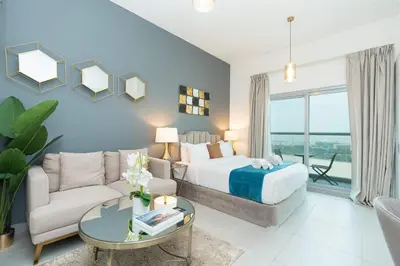 a bedroom with a bed and a couch and a table at PVH - Homely Studio near Miracle Garden in Dubai