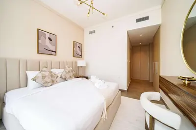 a bedroom with a white bed and a mirror at PVH - Creek Gate - Stylish 2BR with Creek View in Dubai