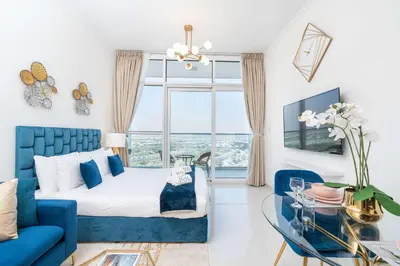a bedroom with a blue couch and a glass table at PVH - Classy Studio with Golf Course View - Carson in Dubai