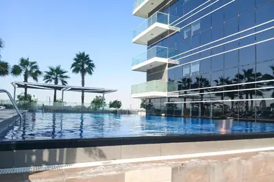 a swimming pool in front of a building at PVH - Classy Studio with Golf Course View - Carson in Dubai