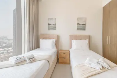 two twin beds in a room with a window at PVH - Forte Tower 1 - Opulent 2BR near Dubai Mall in Dubai