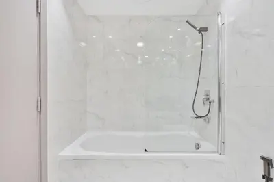 a bathroom with a shower with a white tub at PVH - 2BR near Marina Promenade - Marina Pearl in Dubai