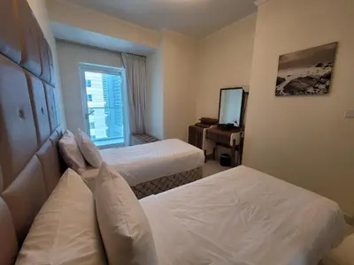 a hotel room with two beds and a mirror at Damac Heights - Blue Ocean Holiday Homes in Dubai