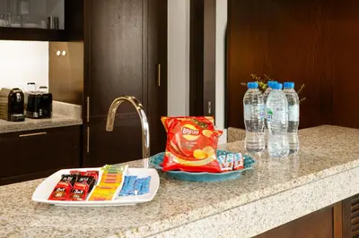 a kitchen counter with soda and chips and bottles of water at Downtown Gem, 1 BDR Apartment, Walk to Dubai Mall & Burj khalifa in Dubai