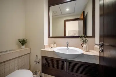 a bathroom with a sink and a toilet and a mirror at Downtown Gem, 1 BDR Apartment, Walk to Dubai Mall & Burj khalifa in Dubai