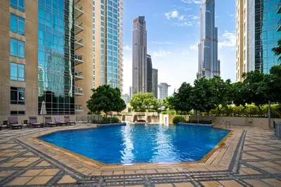 a pool in the middle of a city with tall buildings at Downtown Gem, 1 BDR Apartment, Walk to Dubai Mall & Burj khalifa in Dubai
