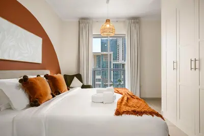 a bedroom with a large white bed with a large window at Downtown Gem, 1 BDR Apartment, Walk to Dubai Mall & Burj khalifa in Dubai