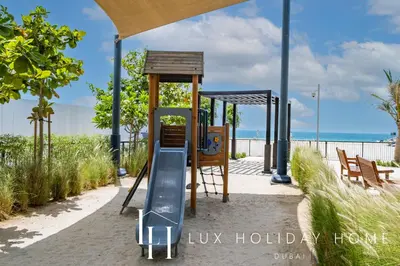 a playground with a slide on the beach at LUX The Le Pont Sea View Suite in Dubai