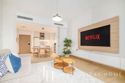 a living room with a tv on a wall at LUX The Le Pont Sea View Suite in Dubai
