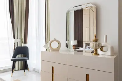 a white dresser with a mirror and a chair at Luxury 3Br Apts with Private Pool in Gemz by Simply Comfort in Dubai