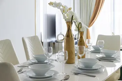 a table with plates and glasses and flowers in vases at Luxury 3Br Apts with Private Pool in Gemz by Simply Comfort in Dubai