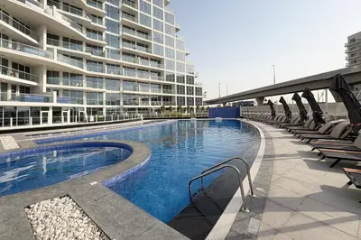a swimming pool in front of a large building at Luxury 3Br Apts with Private Pool in Gemz by Simply Comfort in Dubai