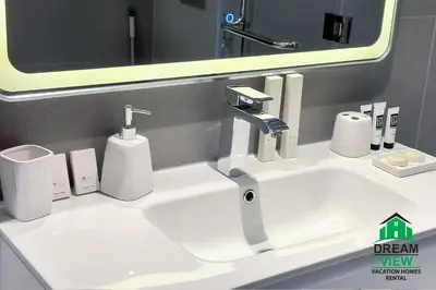 a white sink in a bathroom with a mirror at Souk Al Bahar connected to Dubai Mall, Burj khalifa Partial View Dream View Holiday Home Rental in Dubai