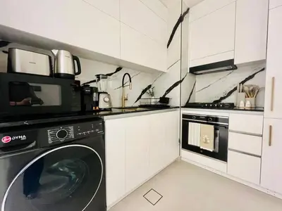 a kitchen with a washing machine and a microwave at Business Bay Studio Jacuzzi & Iconic View in Dubai
