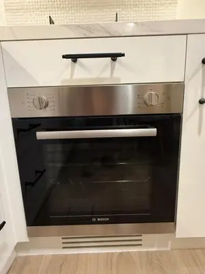 a stainless steel oven in a white kitchen at Appartement moderne et élégant in Dubai