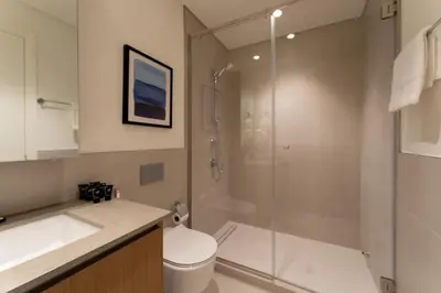 a bathroom with a shower and a toilet and a sink at Maison Privee - Serene Hideaway with Top Facilities in Creek Beach in Dubai