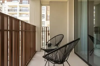 a balcony with two chairs and a glass table at Maison Privee - Serene Hideaway with Top Facilities in Creek Beach in Dubai